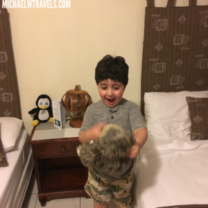 a boy jumping in the air with a stuffed animal