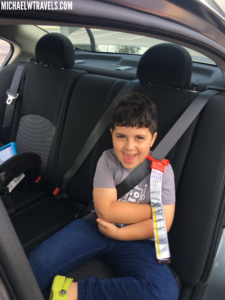 a boy sitting in a car with a seat belt