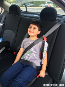 a boy sitting in a car with a seat belt