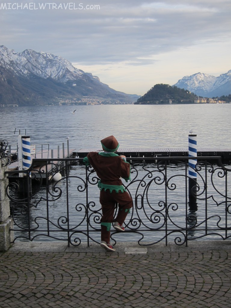 a person in garment standing on a railing overlooking a body of water