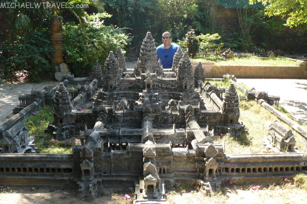 a man standing in front of a model of a castle