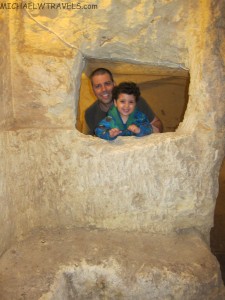 a man and child looking through a hole in a rock wall