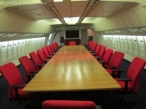 a long table with red chairs in an airplane