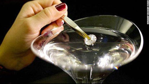 a person holding a tweezers in a martini glass