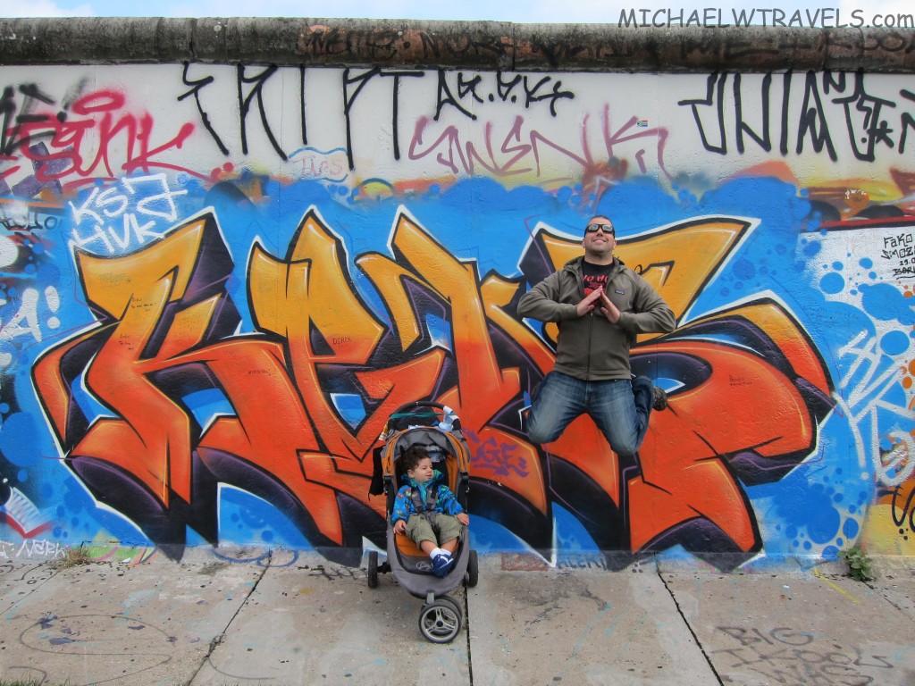 a man jumping in front of a wall with graffiti