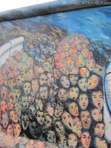 a large group of people's faces on a wall