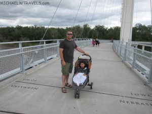a man with a stroller on a bridge