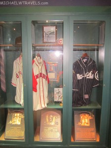a display case with baseball jerseys and trophies
