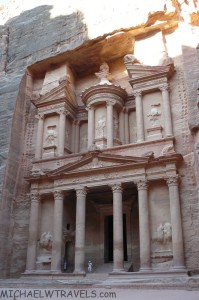 a stone building with pillars with Petra in the background