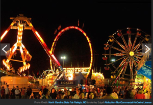 a carnival at night with a ferris wheel and a ferris wheel
