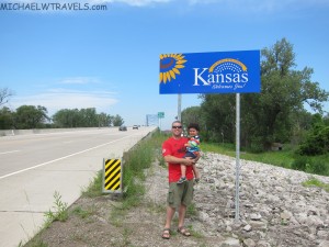a man holding a child in front of a sign