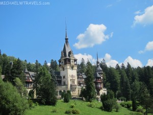 Peleș Castle with a tower and trees