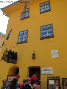 a yellow building with people walking in the doorway
