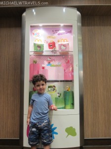 a boy standing in front of a display case