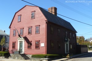 a red house with a white door with White Horse Tavern in the background