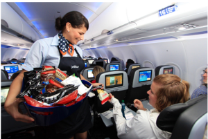 a flight attendant serving a woman