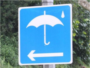 a blue sign with an umbrella and an arrow