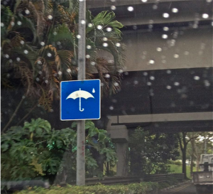a sign on a pole with an umbrella on it