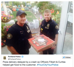 two police officers holding a pizza box