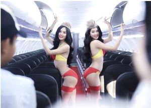 two women in garments posing in an airplane
