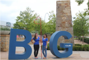two women standing next to large letters