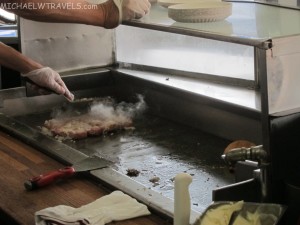 a chef cooking meat on a grill
