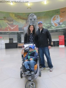 a man and woman standing next to a baby in a stroller