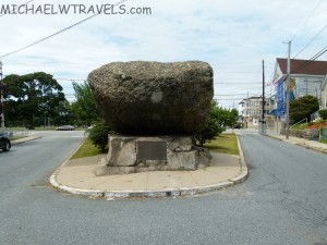 a large rock on a street corner