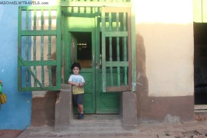 a child standing in front of a green door