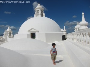 a boy standing in front of a white building
