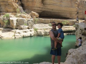 a man holding a child in front of a body of water