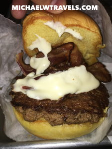 a burger with bacon and white sauce