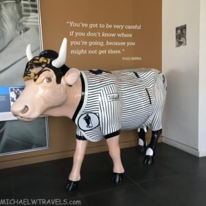 a statue of a cow wearing baseball uniforms