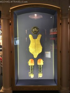 a glass case with a bodysuit and a mask