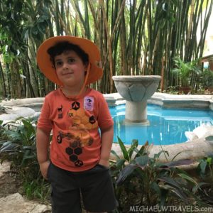 a boy standing in front of a pool