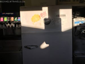 a white refrigerator with a broken sticker