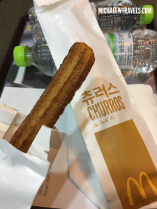 a churro in a wrapper on a tray