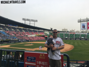 a man holding a baby in a baseball stadium