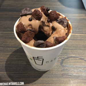 a cup of ice cream with brown food on top