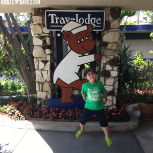 a boy jumping in front of a sign