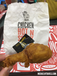 a hand holding a fried chicken leg