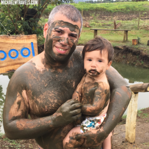 a man holding a baby with mud on his face