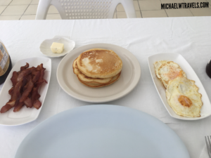 a plate of pancakes and bacon on a table