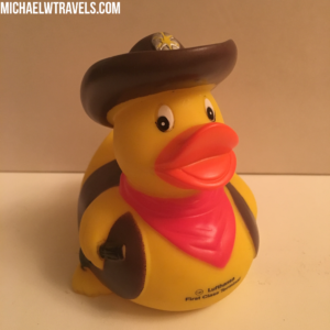a yellow rubber duck with a cowboy hat and red scarf