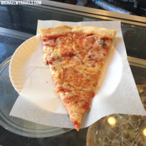 a slice of pizza on a paper plate