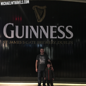a man and child standing in front of a sign