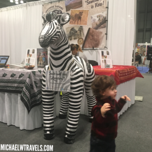 a child standing next to a zebra statue