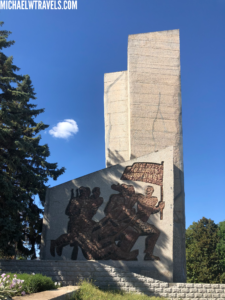 a monument with a picture of soldiers and a flag