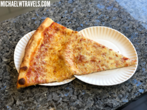a slice of pizza on a paper plate