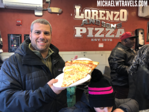 a man holding a slice of pizza
